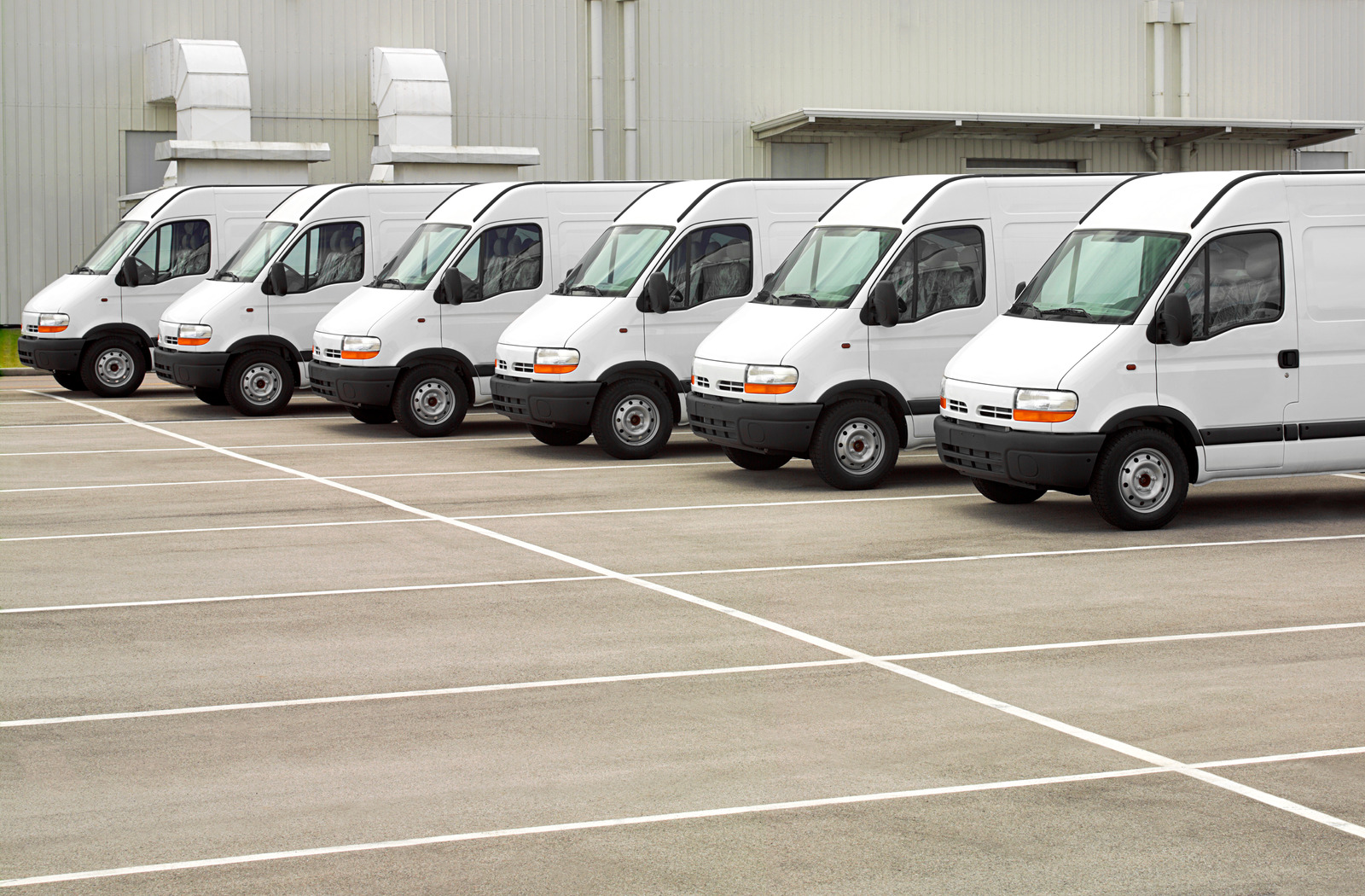 Fleet of white commercial vans ready for mobile detailing